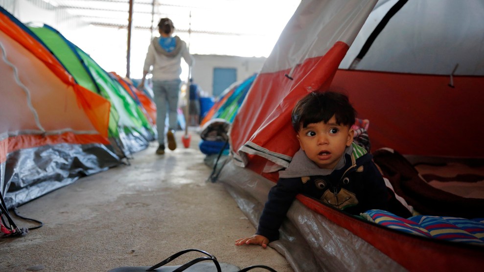 A 10-month-old looks out from his family's tent in a shelter for migrants in Tijuana, Mexico.