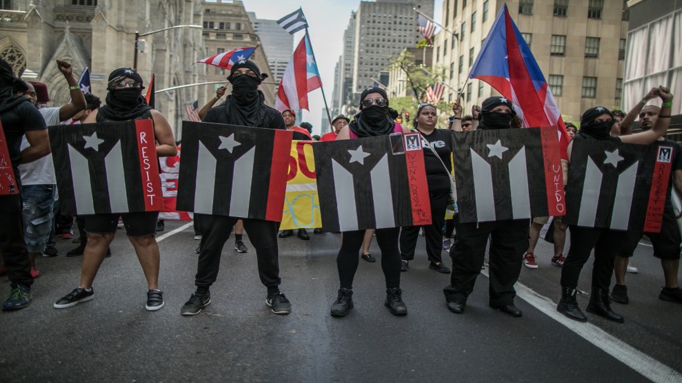Participants hold signs with the Puerto Rico's flag painted in black and white as symbol of resistance and civil disobedience during the NYC's 60th annual Puerto Rico Day parade on June 11, 2017 in New York City.