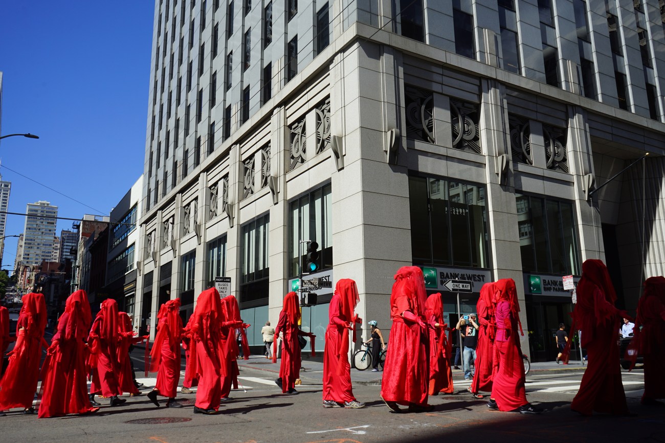 Calling themselves "the Red Rebels," a flock of demonstrators in canary red robes moved dramatically slowly through the streets.