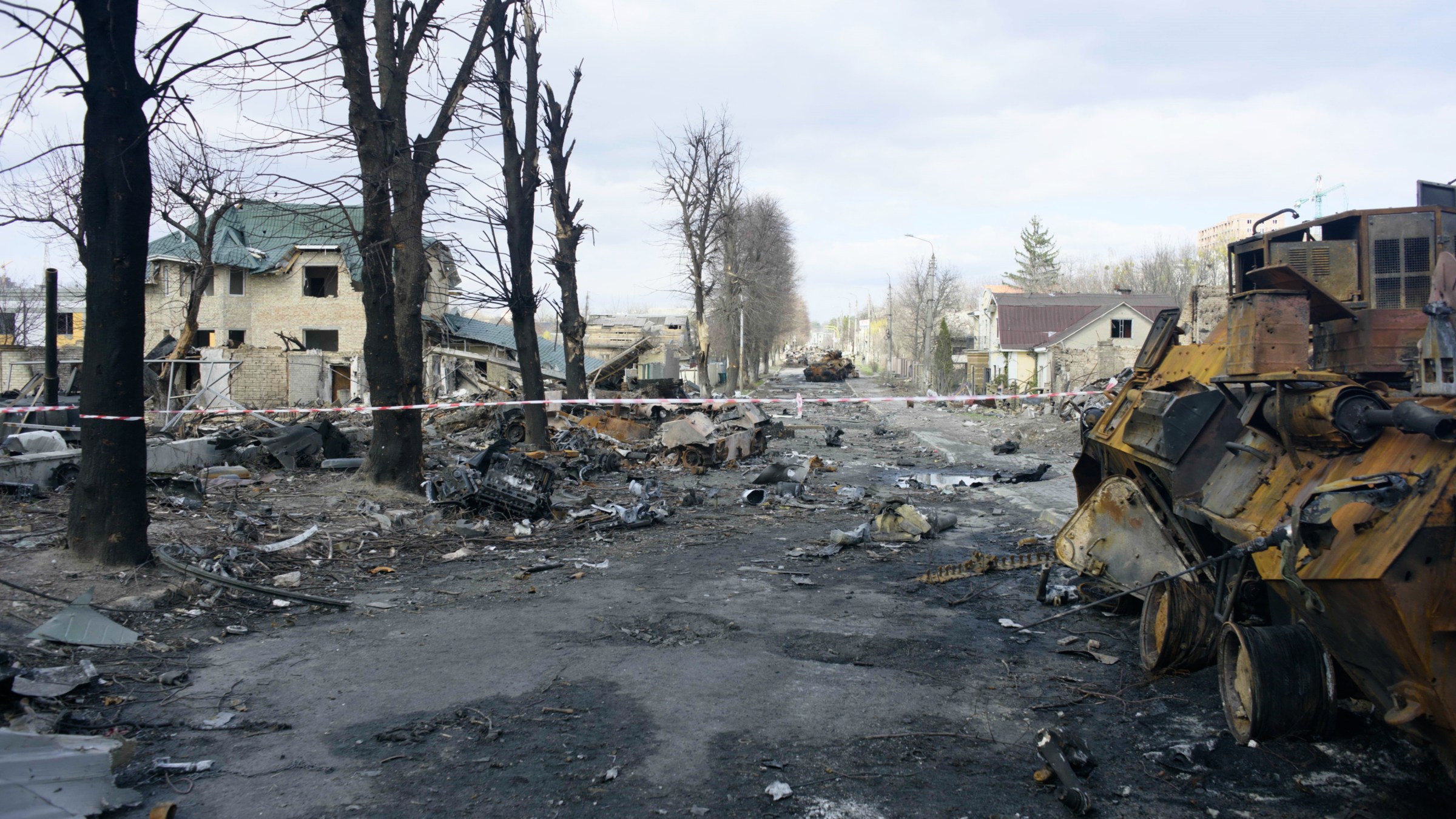 A street filled with ruble and destroyed military equipment.