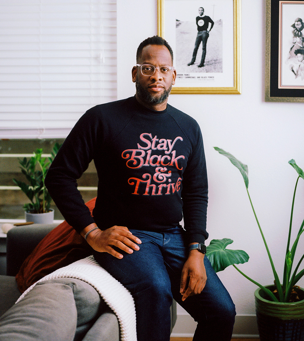 Portrait of a man sitting on the edge of a couch.