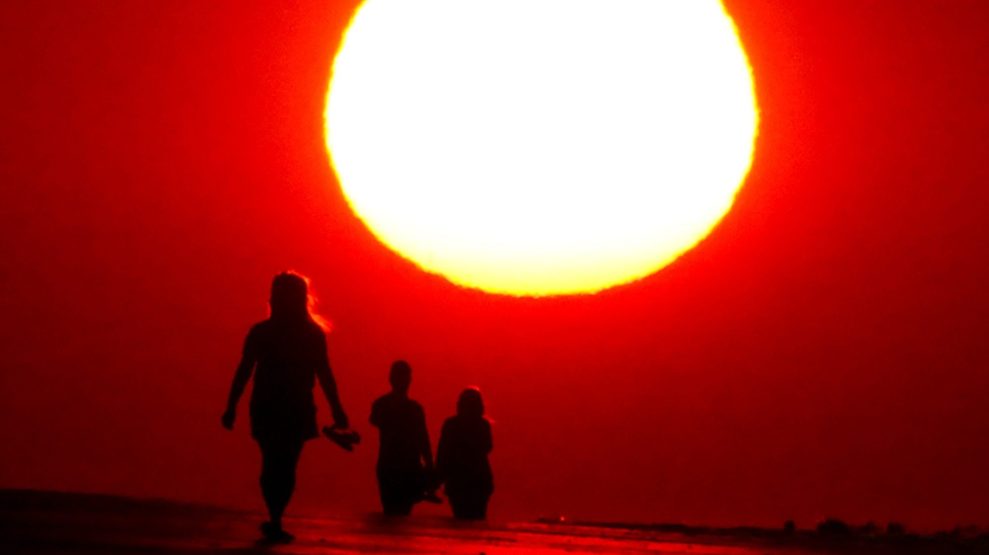 People walk along the street under the sun