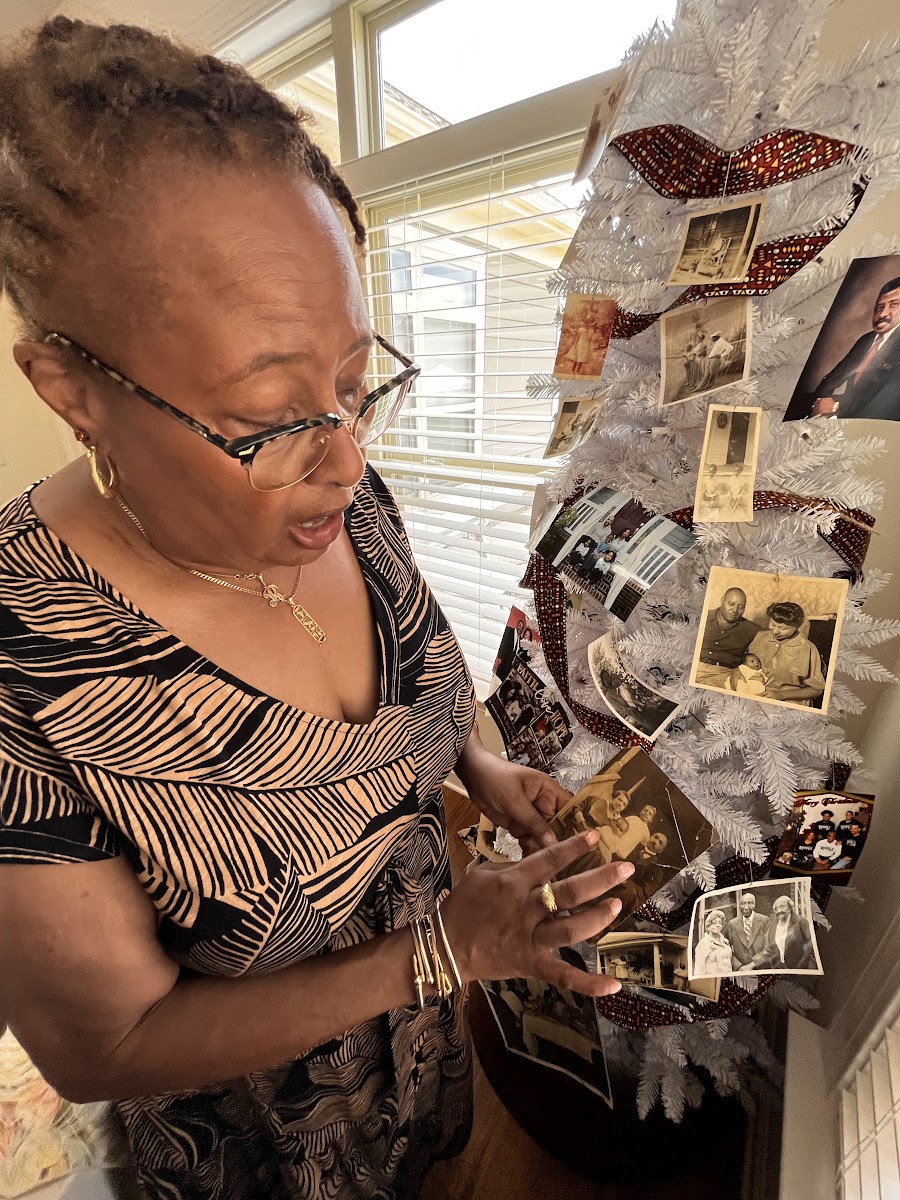 A woman in eyeglasses showing preserved family photos.