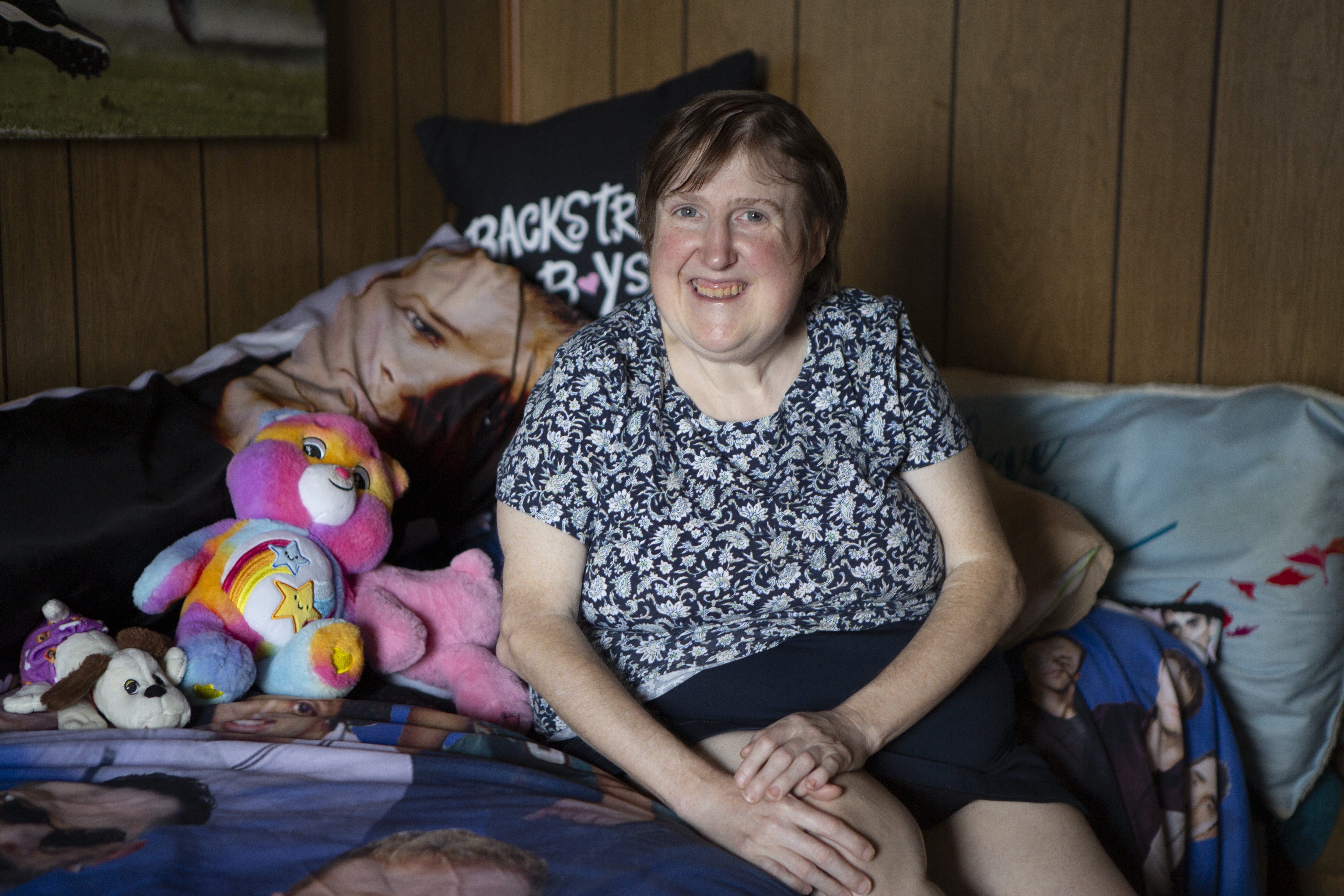 Woman sitting in a bed, smiling. 