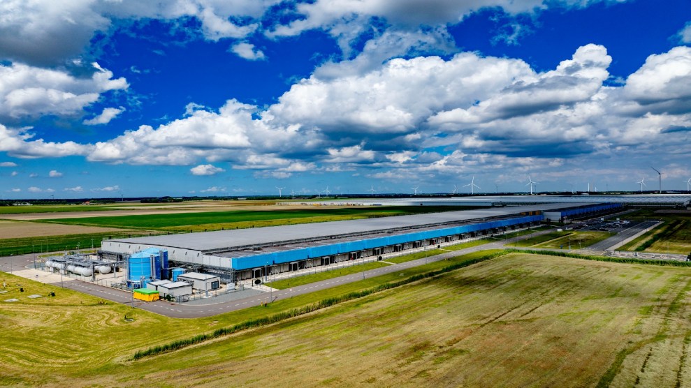 Google data center sits in front of a crowd of wind turbines.