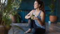 A woman with a glass of green juice