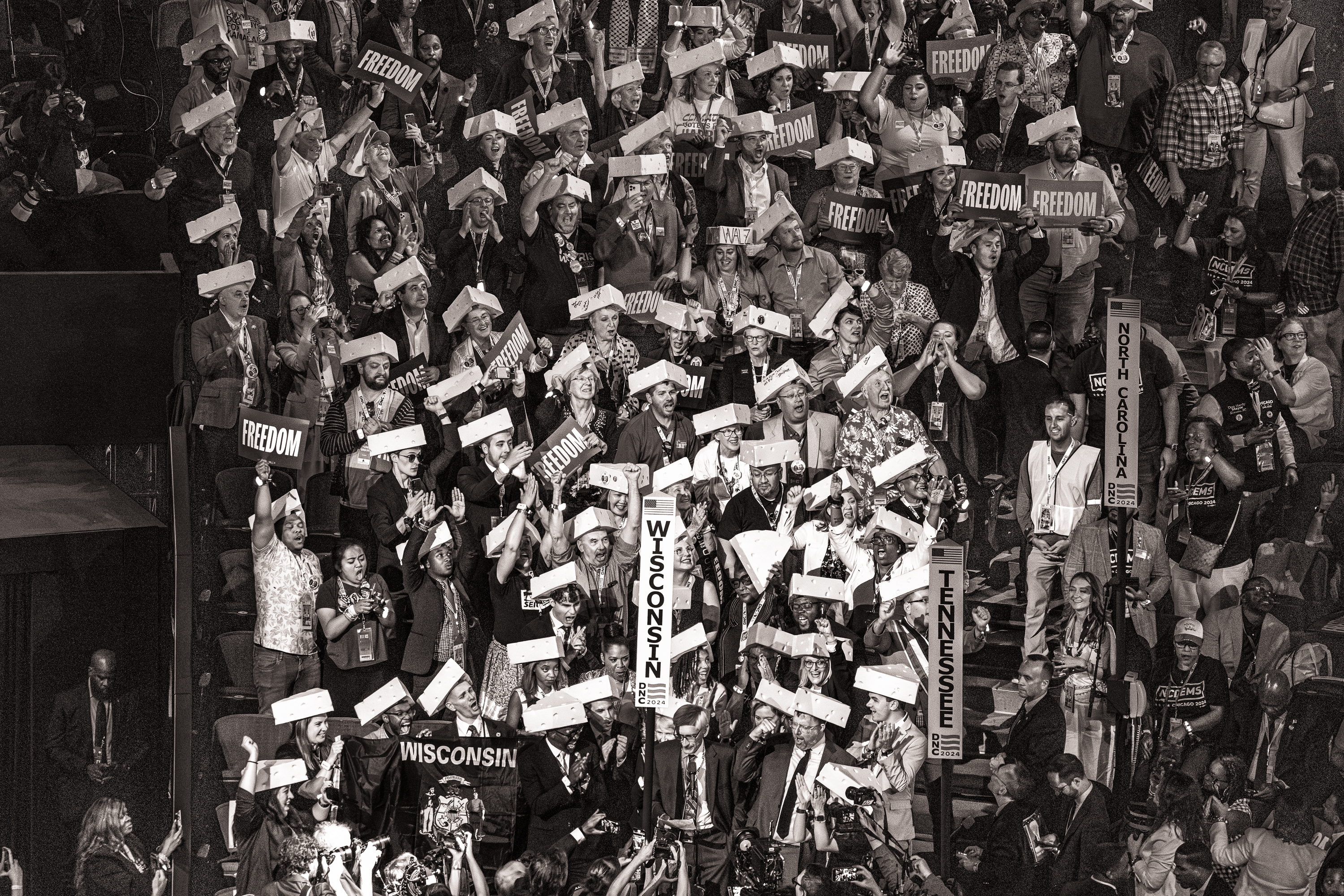 Black and white photo of the Wisconsin delegation at the DNC, many of them wearing cheese wedge-shaped hats.