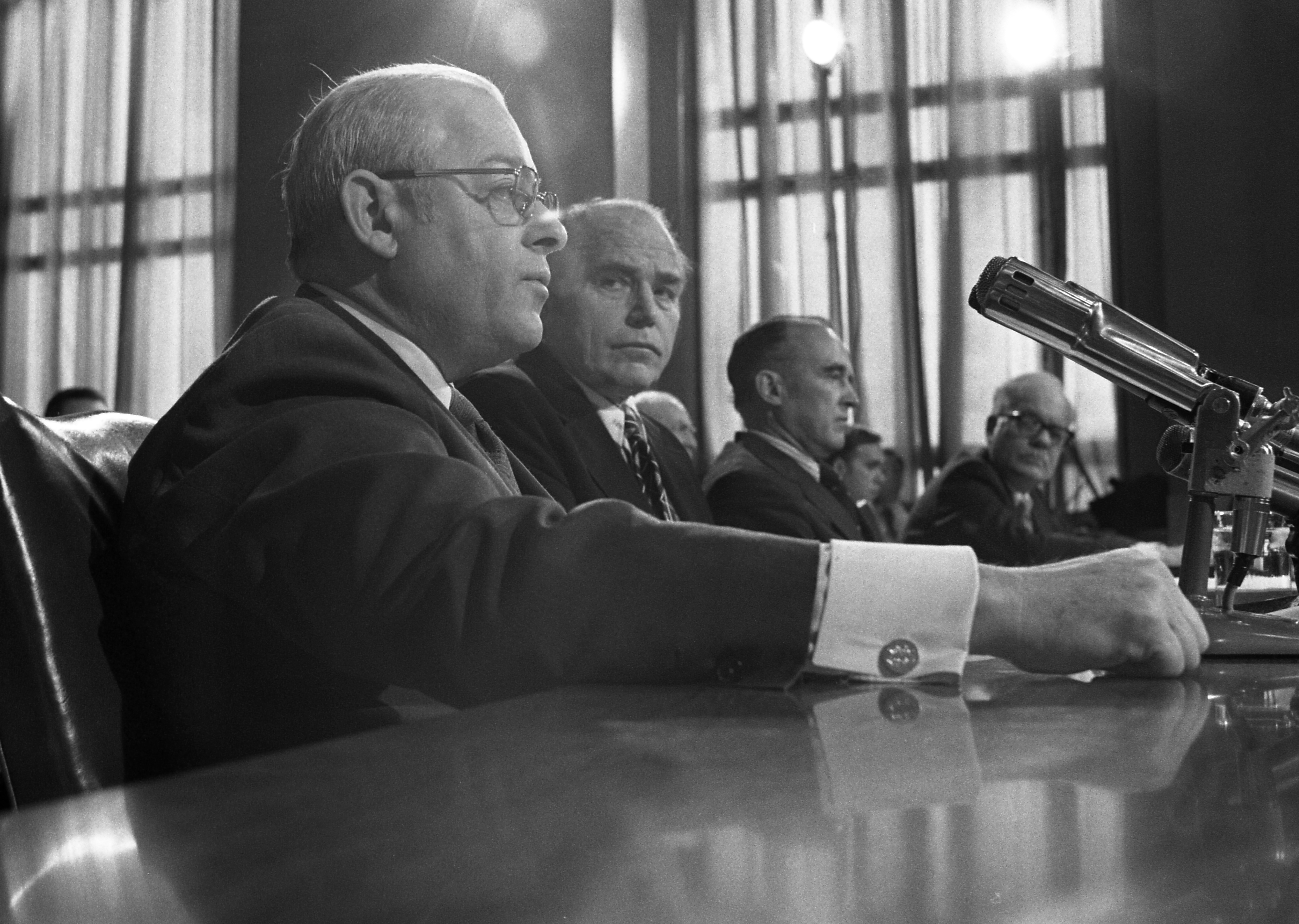 Black and white photo of businessmen sitting at a desk in Congress. 