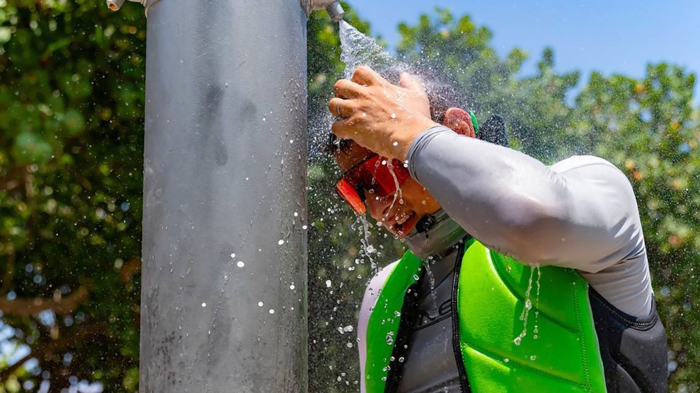 a man in Florida stands under a cold show during a heat advisory