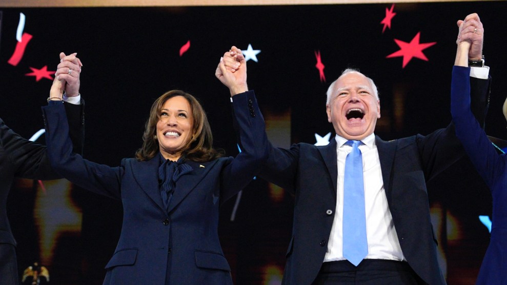 Kamala Harris and Tim Walz put their hands up while on stage at the Democratic National Convention