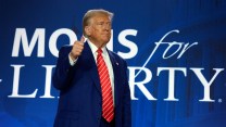 Trump gives a thumbs-up in front of a "Moms for Liberty" logo