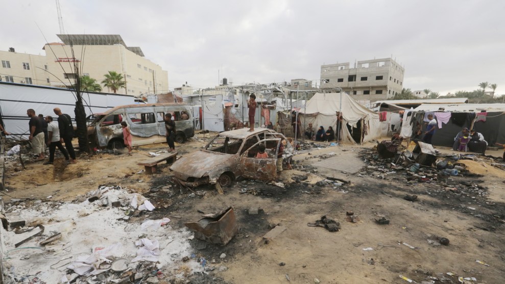 Palestinians sit at the site of an Israeli airstrike which hit tents for displaced people two days earlier in the courtyard of Al-Aqsa Martyrs Hospital in Deir al-Balah in the central Gaza Strip