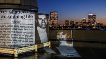 An image from a newspaper article about the death of Carol Stuart is projected on to the Boston skyline at night.