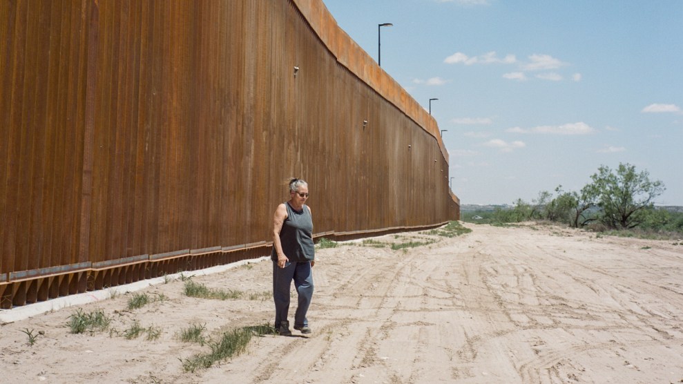 Woman standing near the border wall.