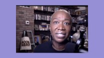 Joy Reid, a middle-aged black woman with short blond hair, sits closely in front of her camera as she speaks. To her left is a microphone, and behind are shelves of books.