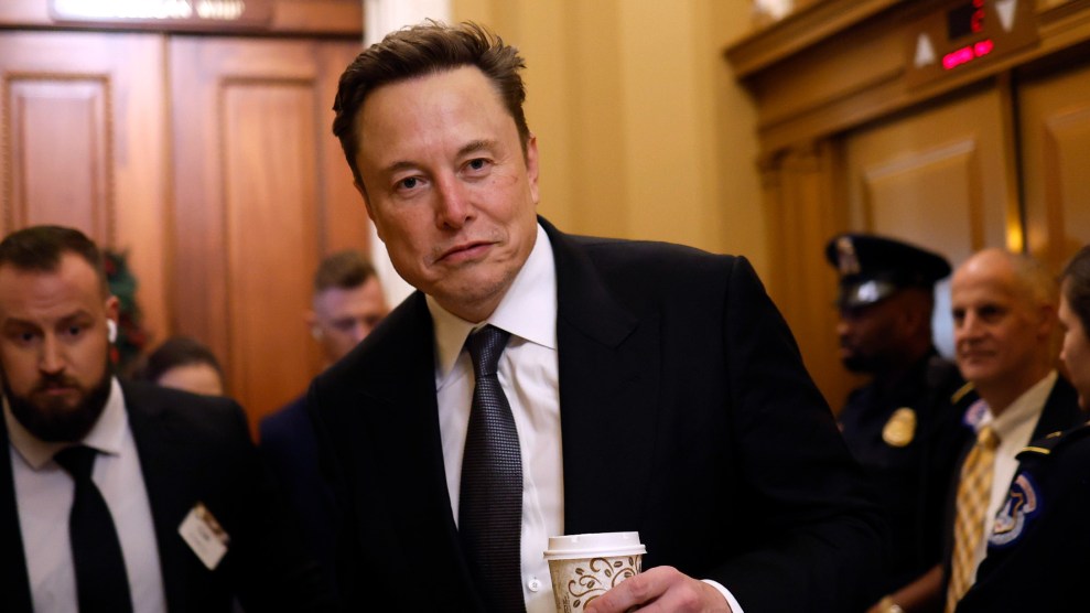 Elon Musk holds a coffee cup.