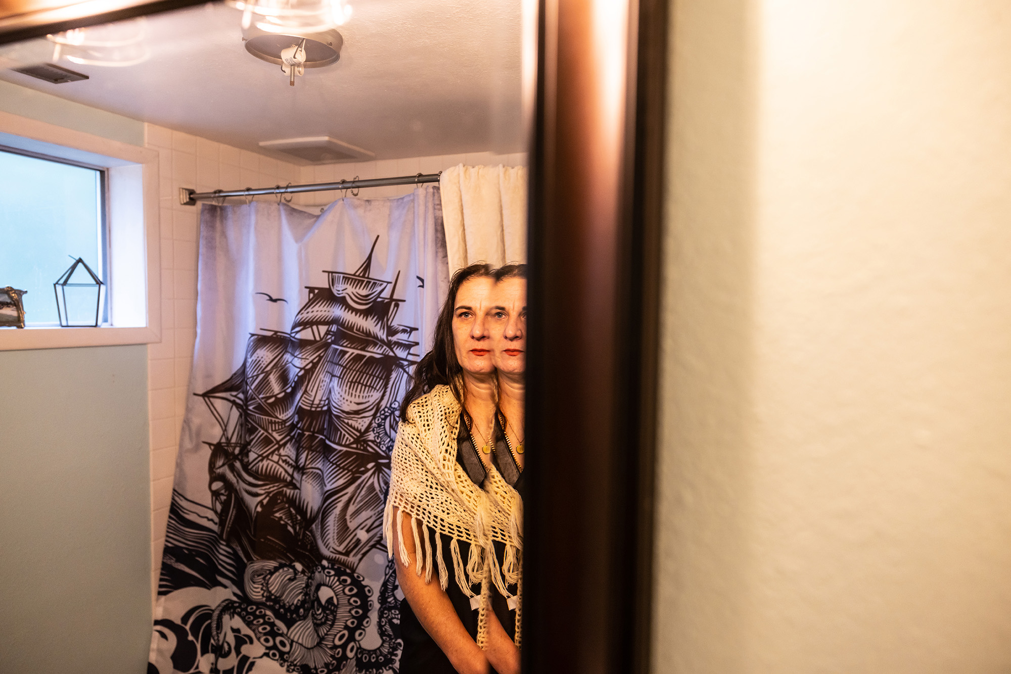 Woman looking into a bathroom mirror.