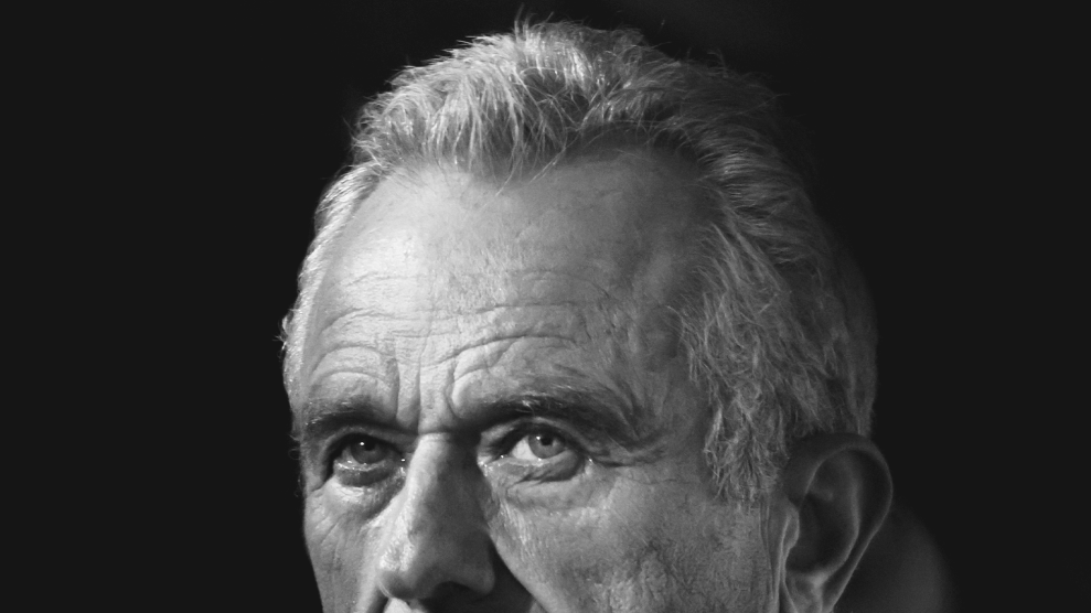 A black and white photo of RFK Jr. The photo has been cropped to show his face from the nose up. Details in the photo reveal the wrinkles around his eyes and forehead as well as the wavy details of his silver hair.