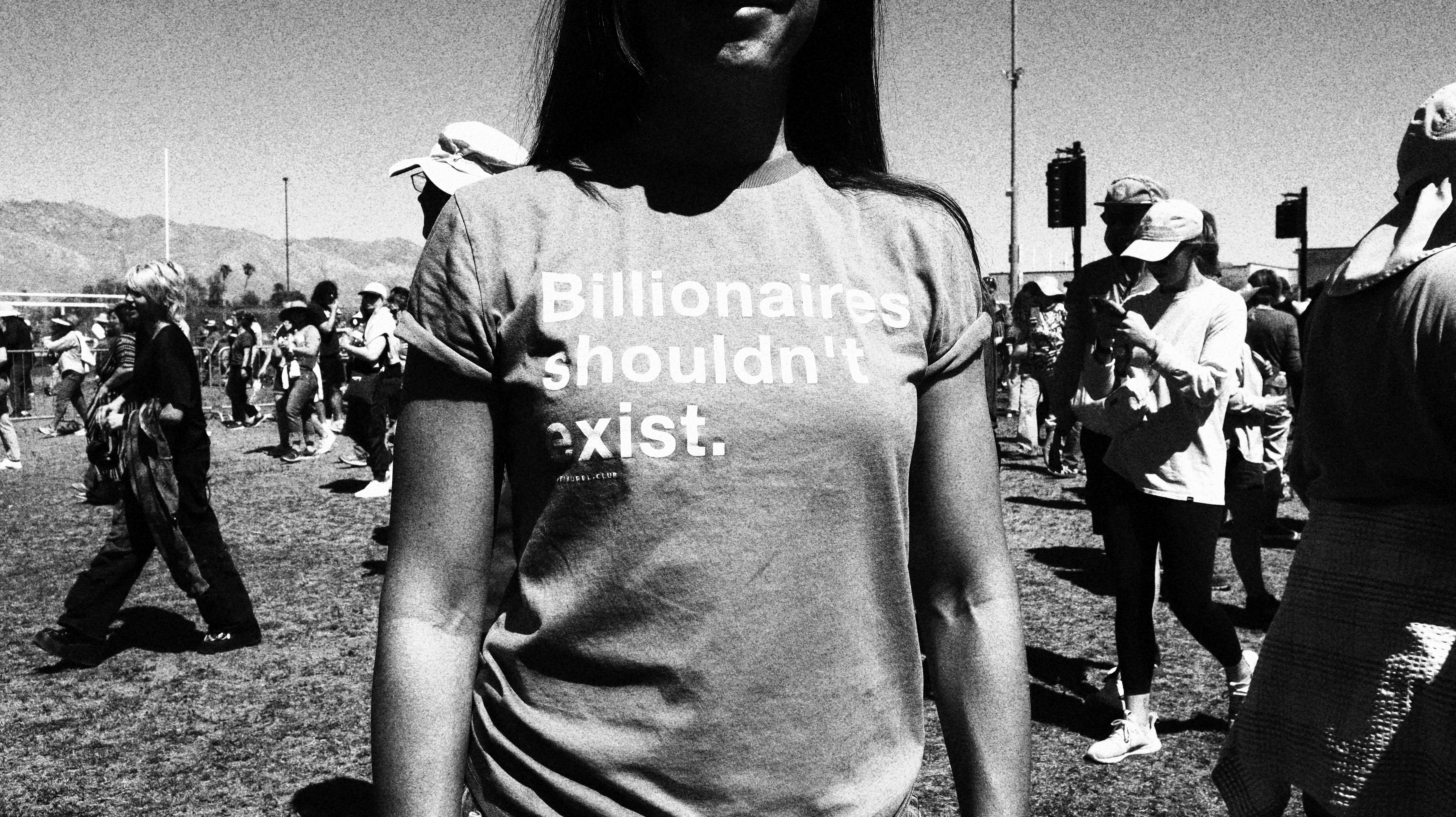 A woman wears a T-shirt that reads, "Billionaires shouldn't exist."