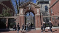 gate to Harvard University with pedestrians