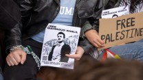 Students chained to Columbia's gates hold signs reading "Free Mahmoud Khalil" and "Free Palestine"