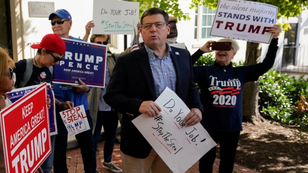 Ed Martin stands among protesters at a "Stop the Steal" rally. He holds a sign that reads, "Do your job! #StopTheSteal"
