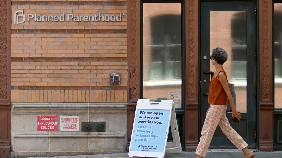 Person walks past the brick facade of a Planned Parenthood building.