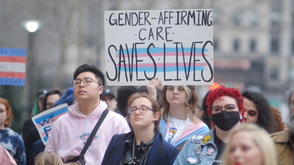 A person holds a sign that says "gender-affirming care saves lives."