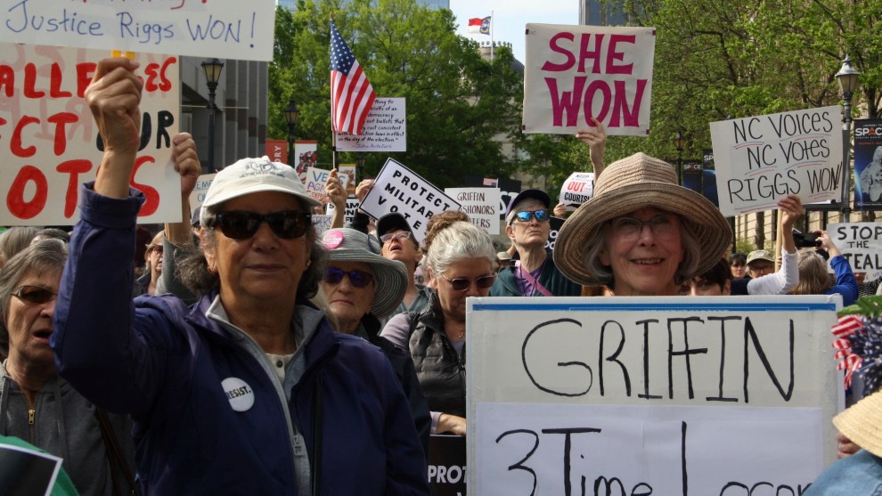 Supporters of Allison Riggs hold signs at a rally. Some of the signs read: "She won," "NC voices, NC votes, Riggs won," and "Griffin, 3 Time Loser."