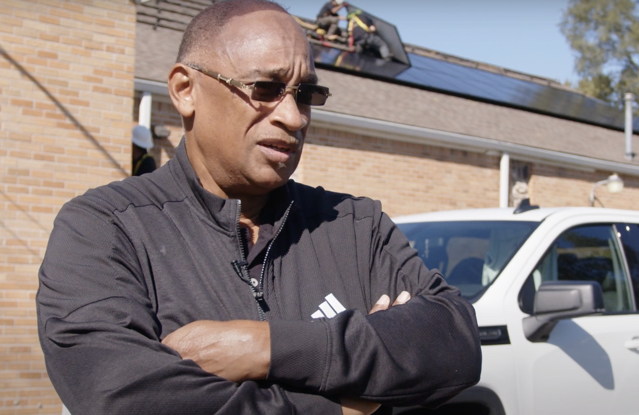 A Black man with crossed arms and sunglasses