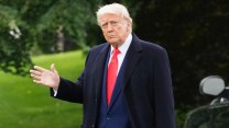 Donald Trump in a blue suit and red tie leaving the White House on May 22.