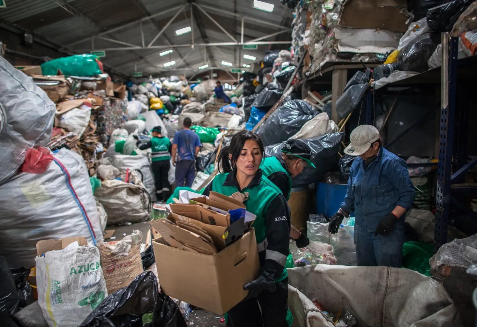 Workers sift through a room full of trash