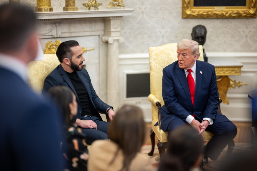 Two men in conversation sit in chairs.