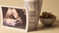 Three items are arranged on a white surface: a salad in a white bowl, a copy of a sonogram, and a printout of a false positive drug test result.