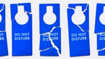 A line of "DO NOT DISTURB" hotel door signs that have been ripped to shreads