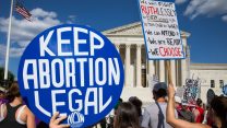 Protestors outside the U.S. capitol hold signs demanding to keep abortion legal