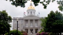 A old gray stone building with a golden dome on top.