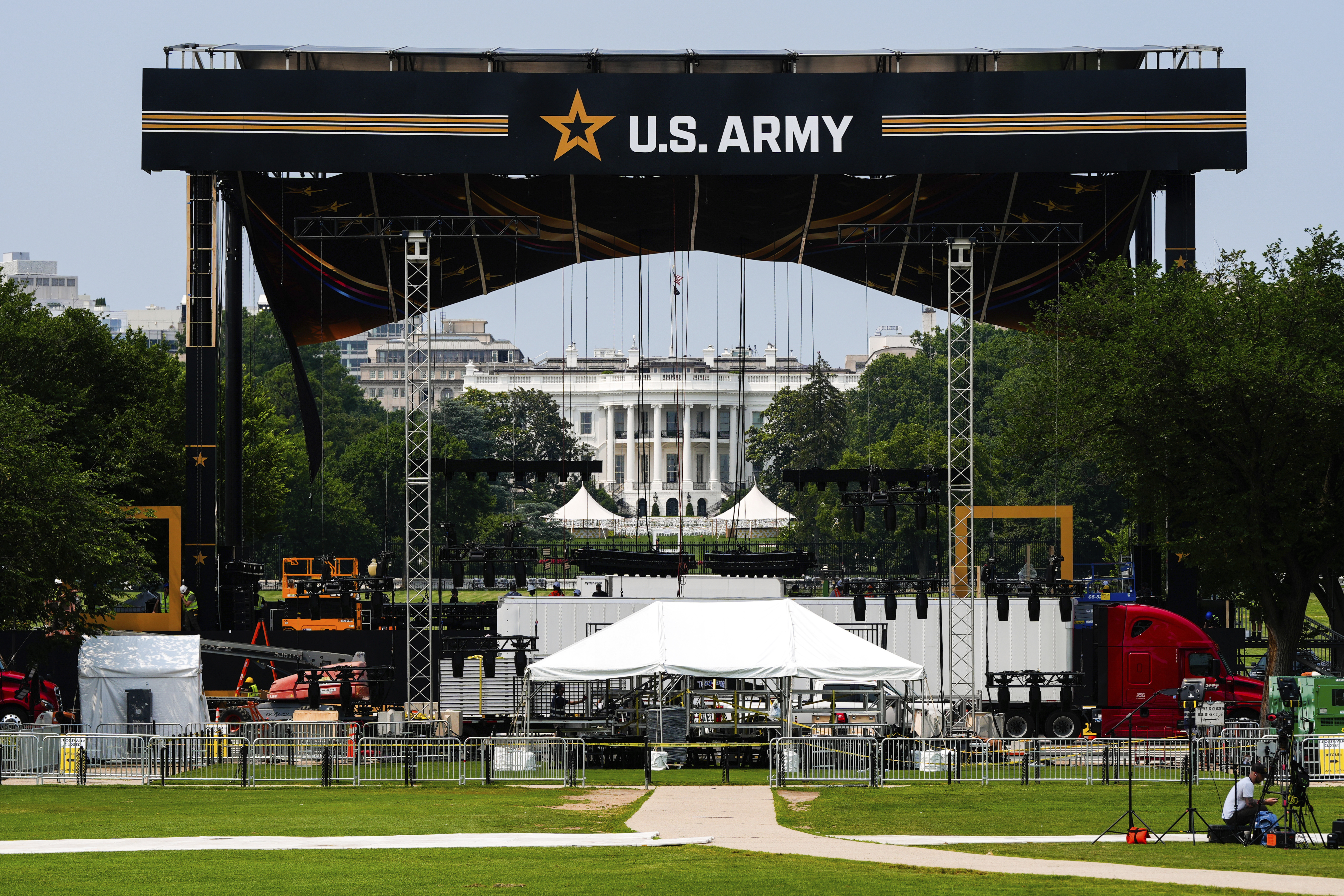 The White House is seen behind a large stage with a US Army banner hung from the top.