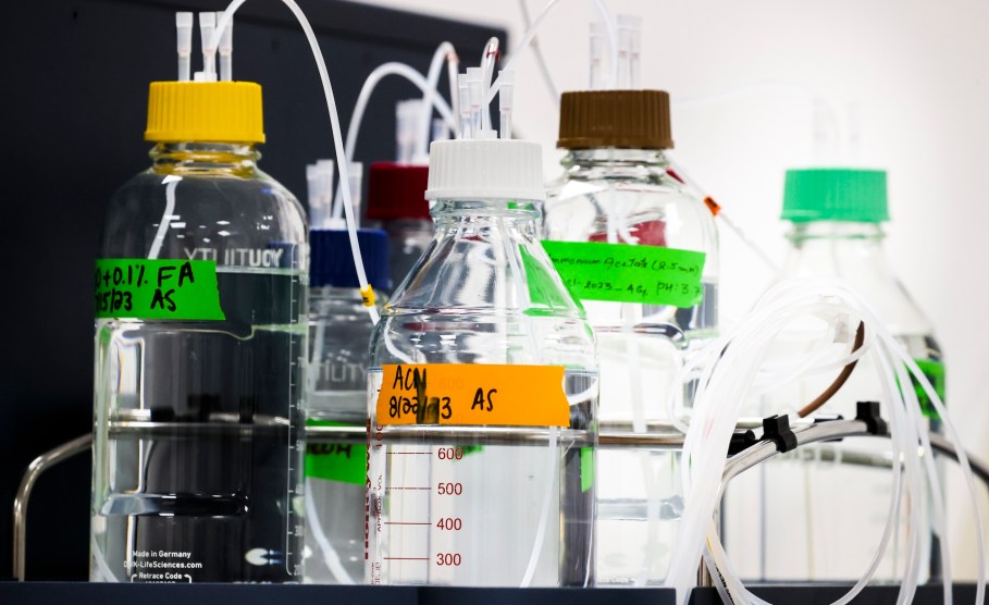 Four bottles with clear liquid and multi-colored labels.