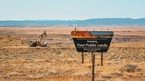 A desert with a sign that say "Entering Your Public Lands"