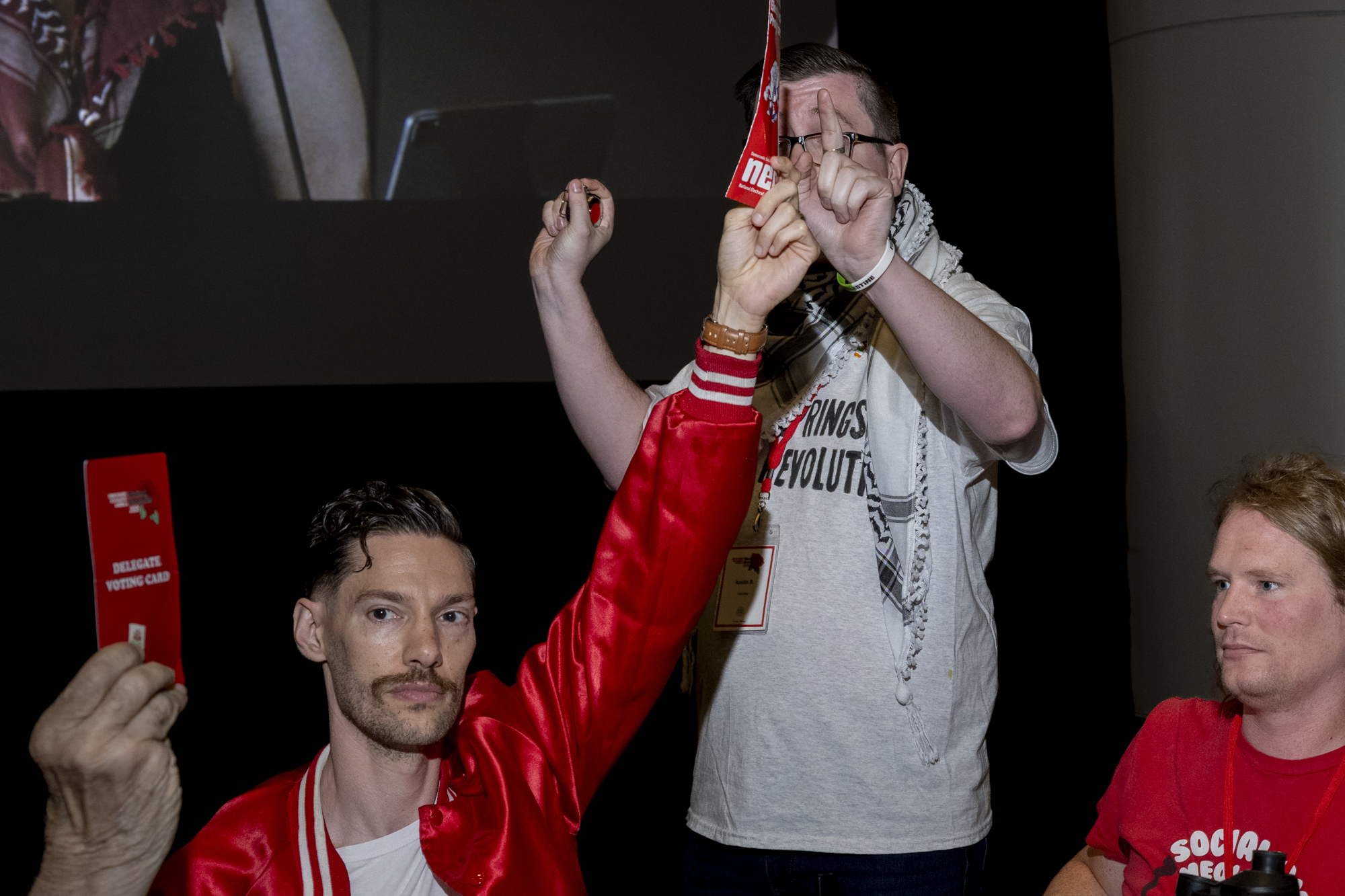 Man in red jacket holds up a red card.