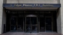 The facade of a building, with the words "J. Edgar Hoover FBI Building" in gold lettering above the entrance