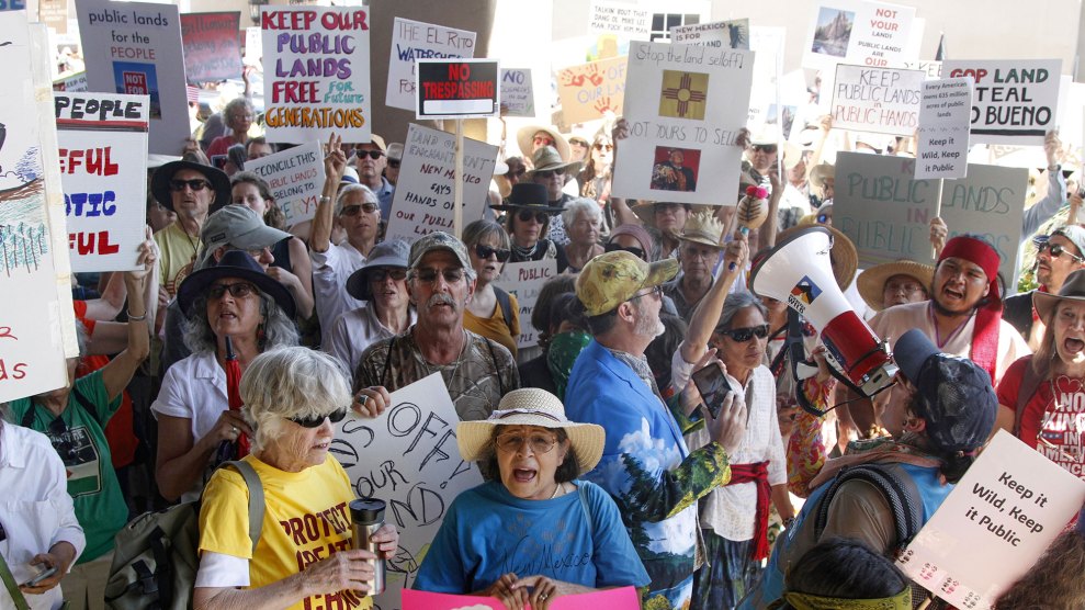 A crowd of protesters with signs opposing proposed sales of public land by the federal government.