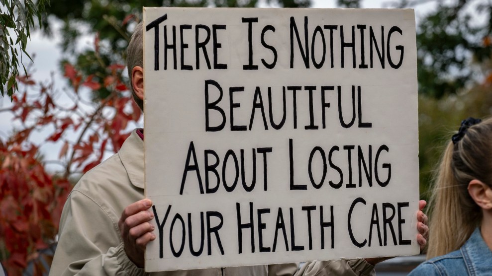 Someone holding up a sign that says "There is nothing beautiful about losing your health care"