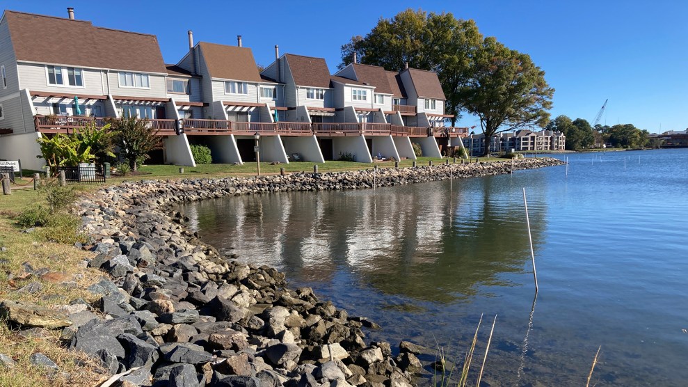 The shore of a coastline park. Houses with red roofs are seen in the distance.