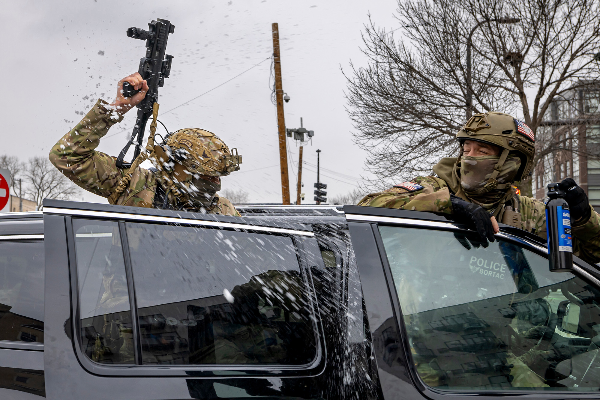 Two ICE agents hanging out of doors of an SUV hit with a snowball.