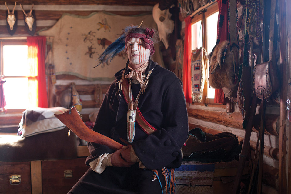 Man dressed as Native American with face paint.