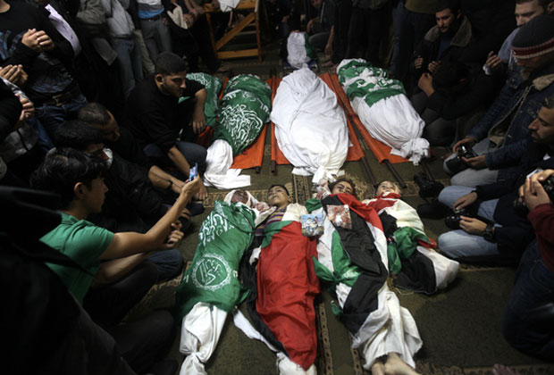 Nov. 19, 2012 - Gaza City, Gaza Strip - Palestinian mourners gather around the bodies of the al-Dallu family during their funeral in Gaza City.  © Majdi Fathi